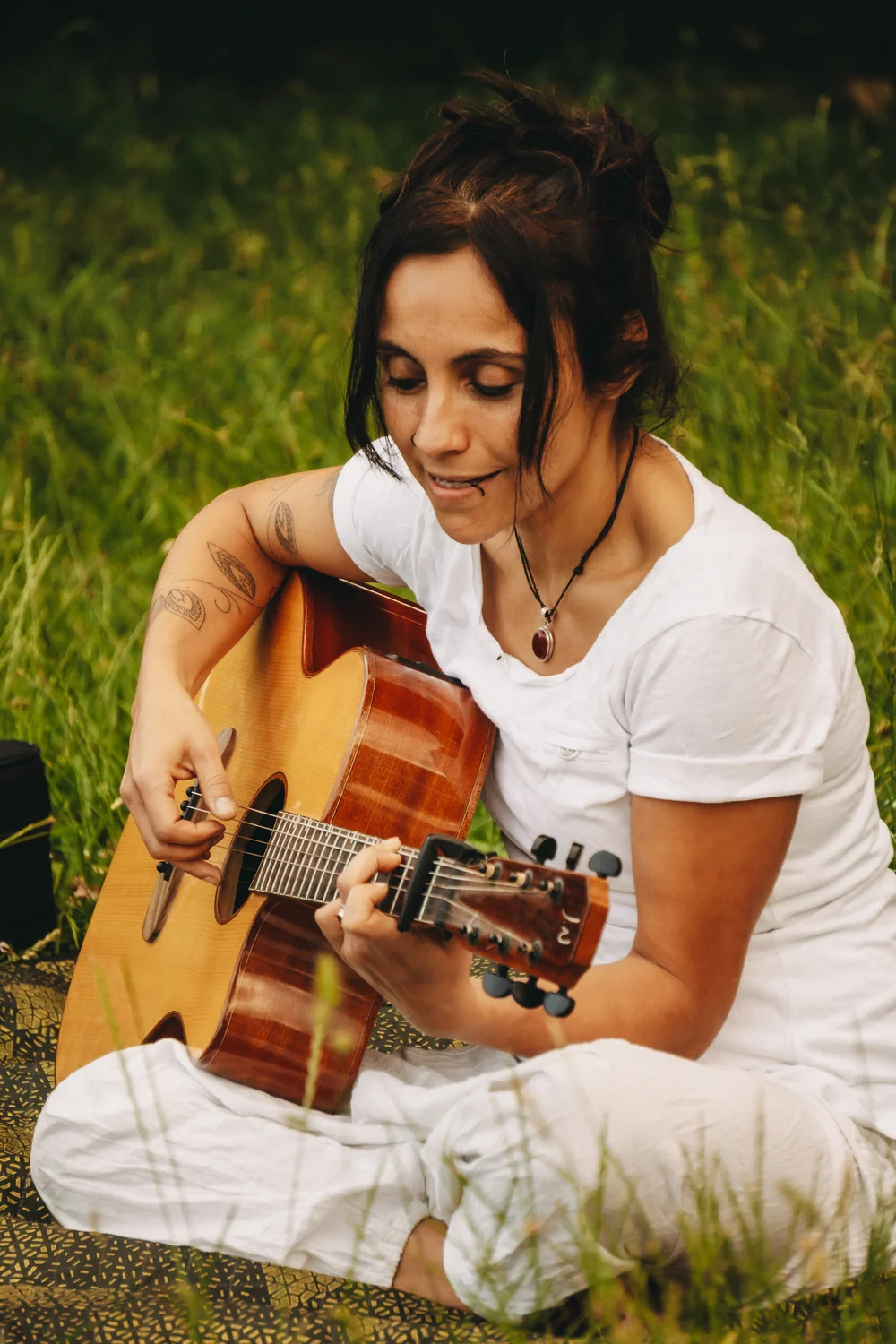 Dani singt und spielt Gitarre im Grünen