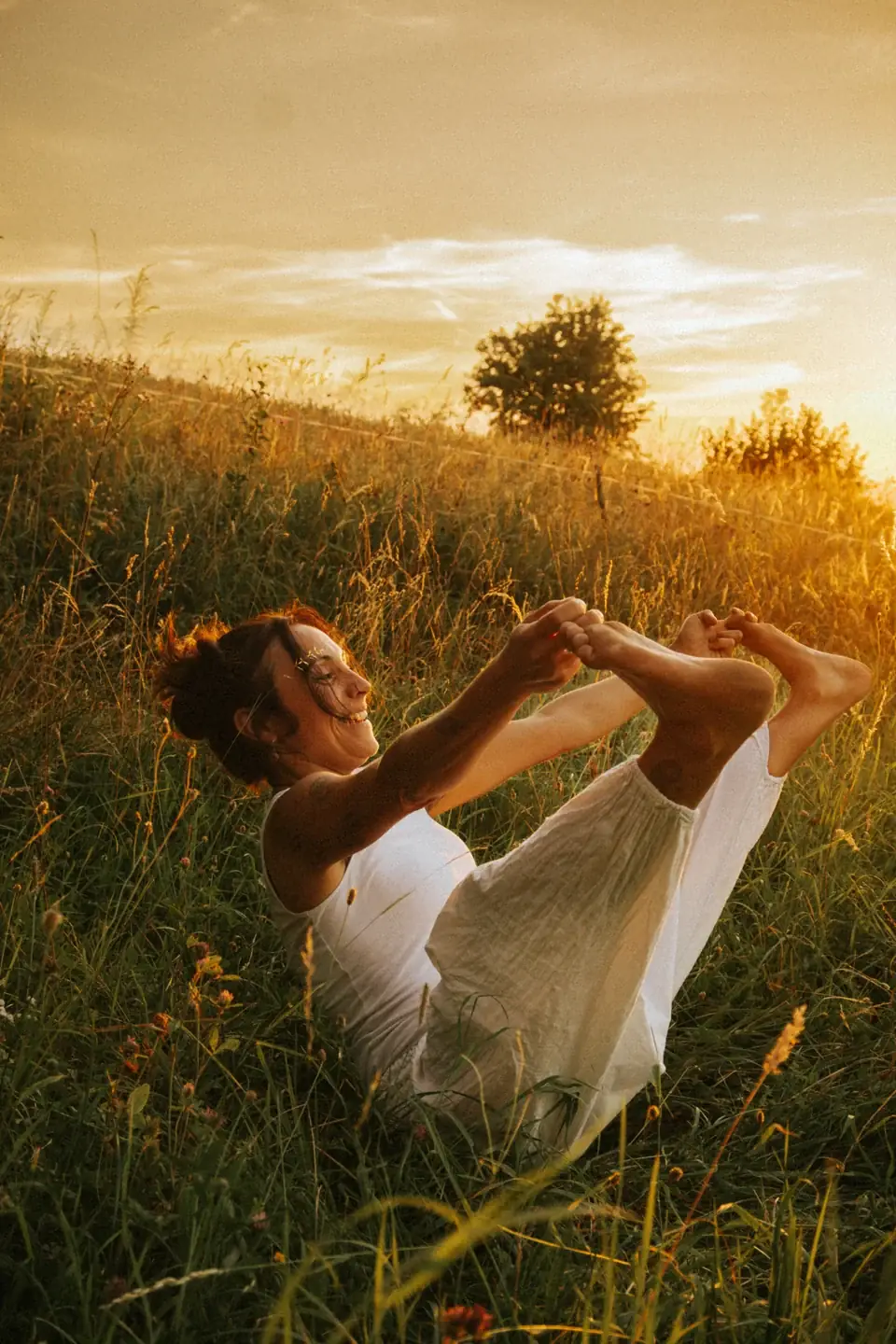 Dani bei einer sitzenden Balanceübung im goldenen Abendlicht