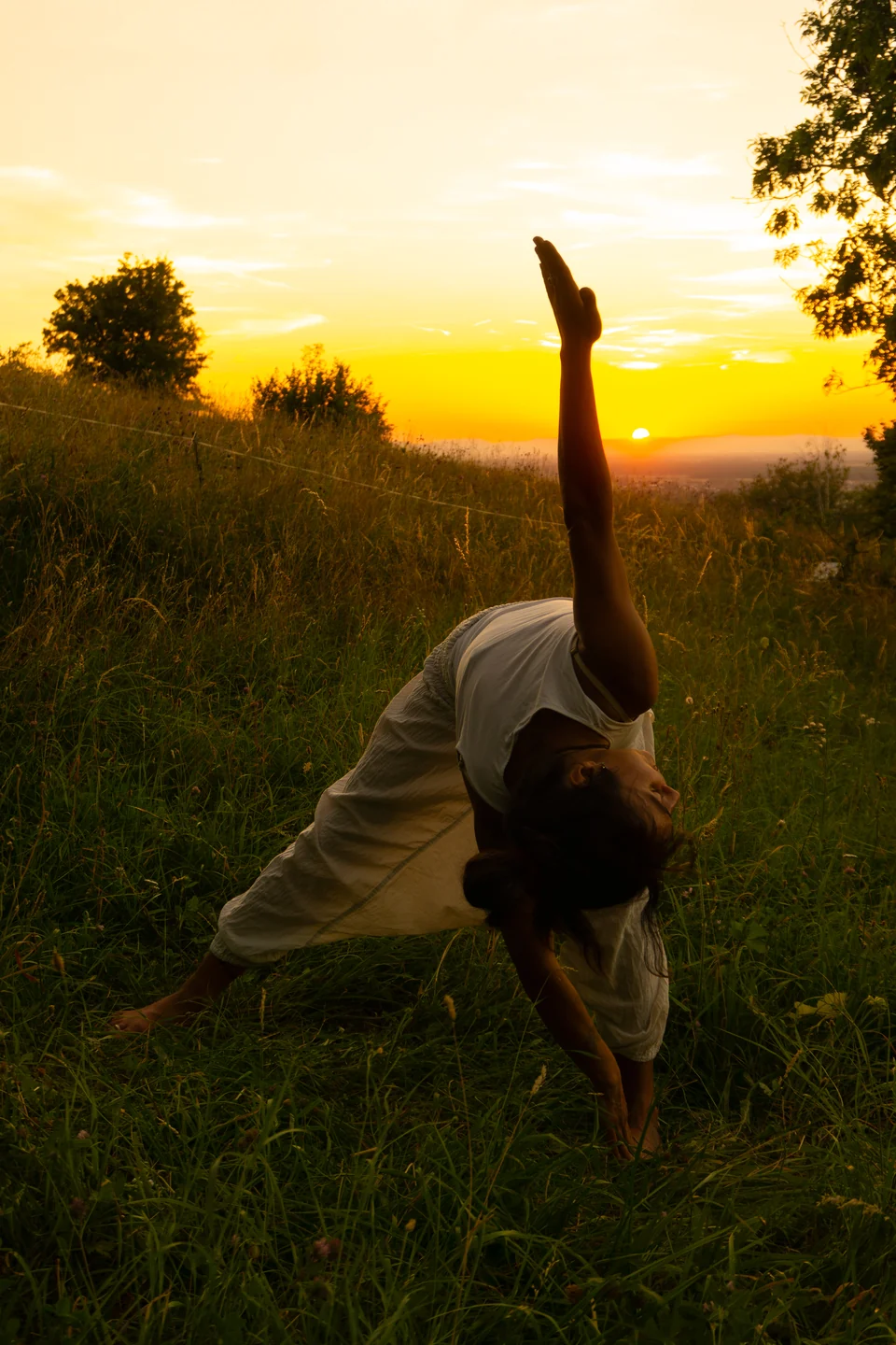 Dani in einer seitlichen Yogahaltung im Abendlicht